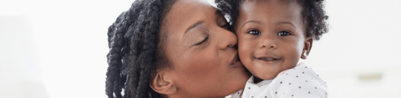 woman kissing child on cheek
